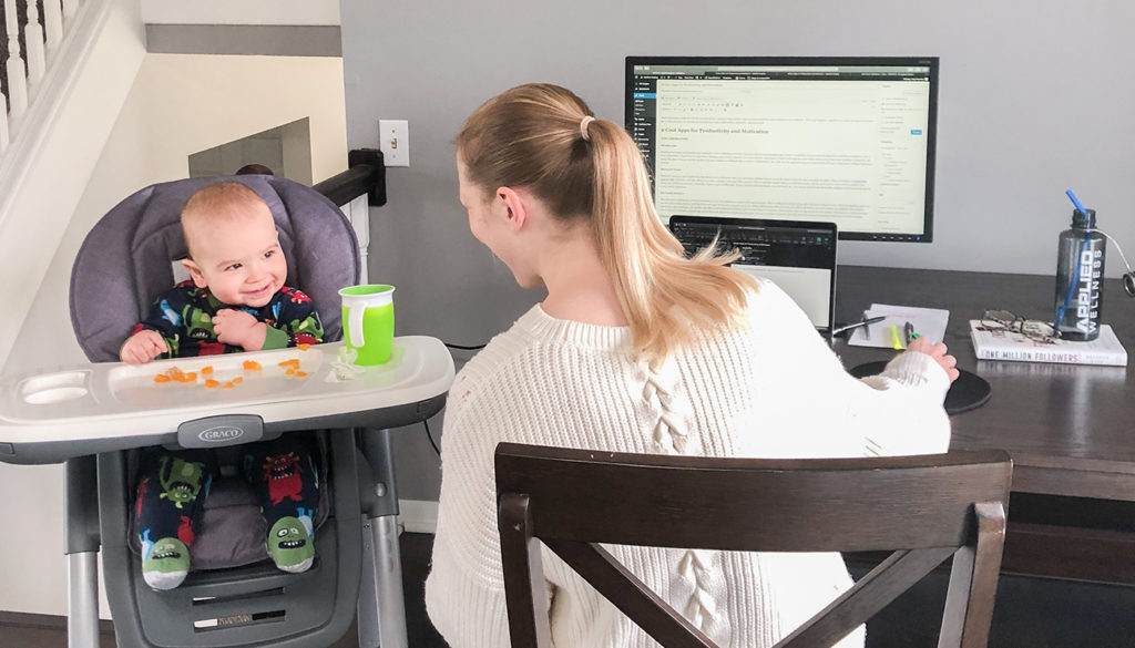 Mom working from home with baby in high chair